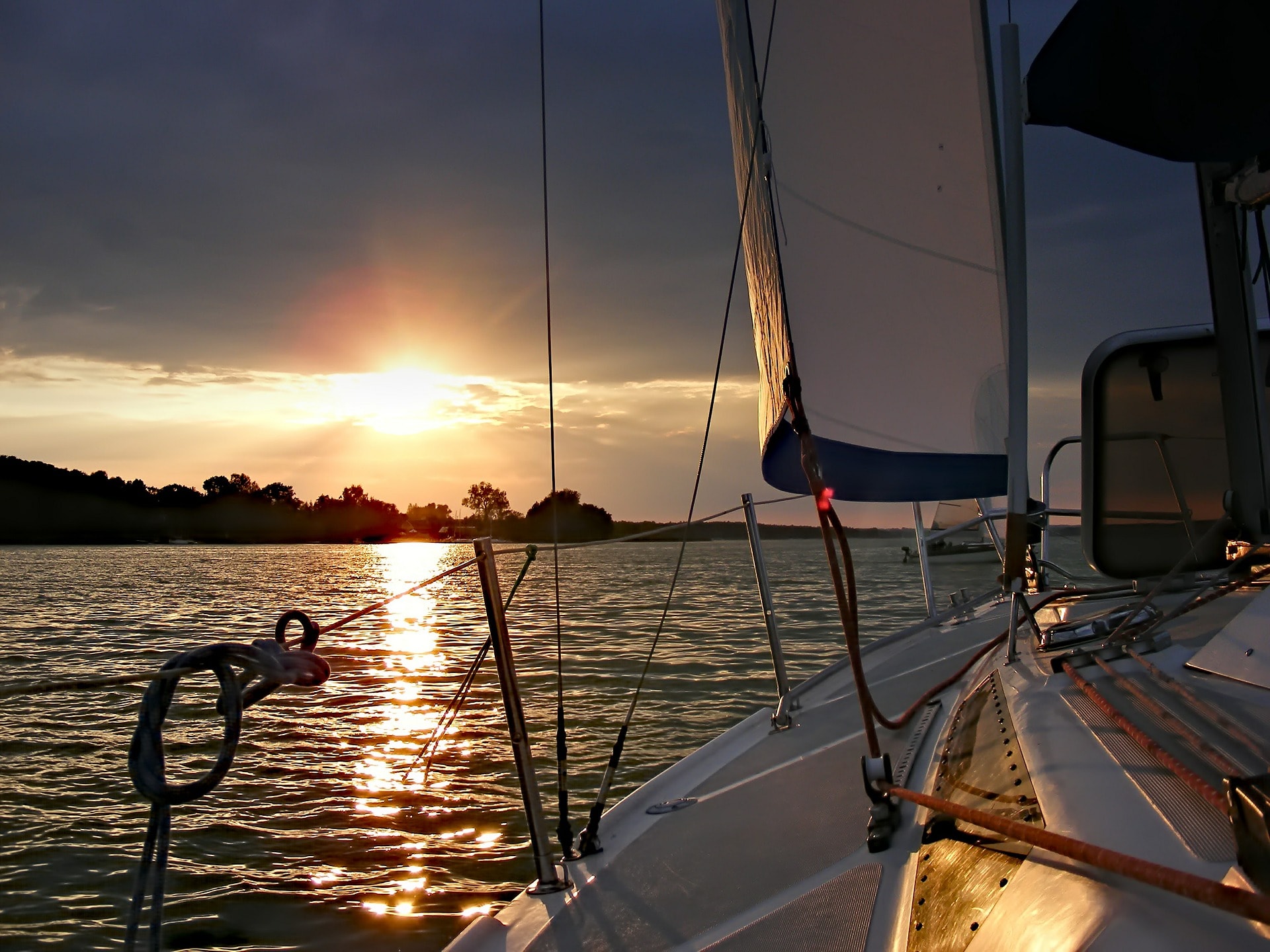 Velero navegando al atardecer en el Río de la Plata — travesías desde Buenos Aires a Uruguay y Argentina